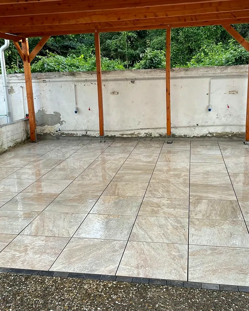 Neu geflieste Terrassenfläche unter einer Holz-Pergola