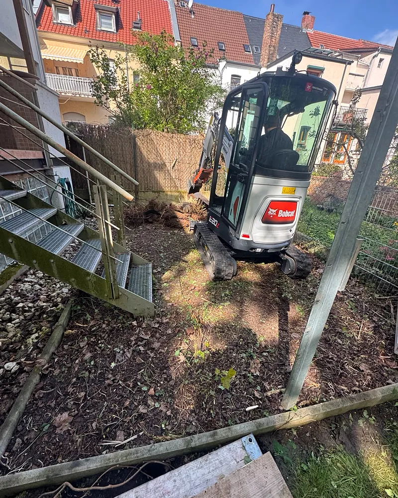 Gartenbau in Worms: Minibagger neben der steilen Metalltreppe beim Erdaushub im terrassierten Reihenhausgarten