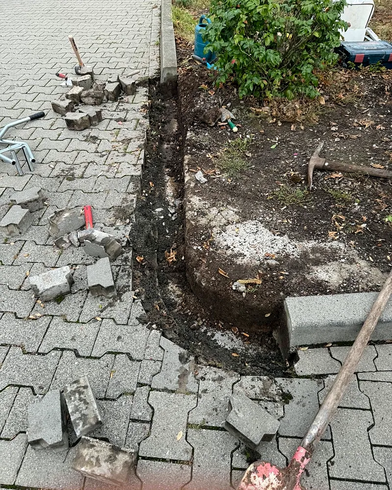 Während der Arbeiten: alte Einfassung entfernt, Werkzeug auf der Pflasterfläche