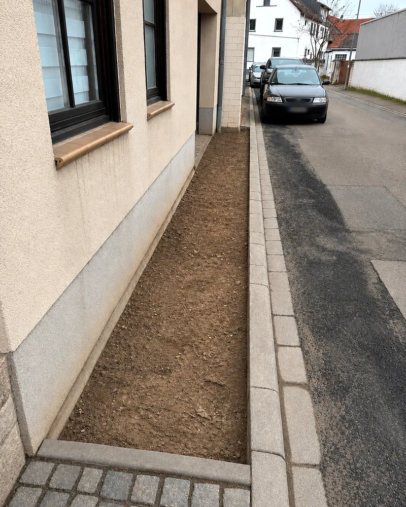 Vorher: schmaler Erdstreifen entlang der Hauswand vor der Pflasterung in Mainz