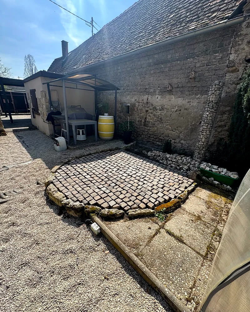 Fertig verlegtes kreisrundes Naturstein-Kleinpflaster im sonnigen Innenhof eines Hofguts in Mainz