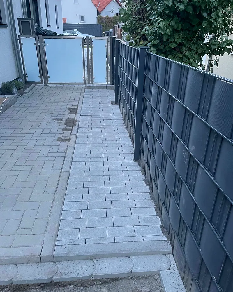 Fertig: gepflasterter Gartenweg mit Glastor und neuem Sichtschutz