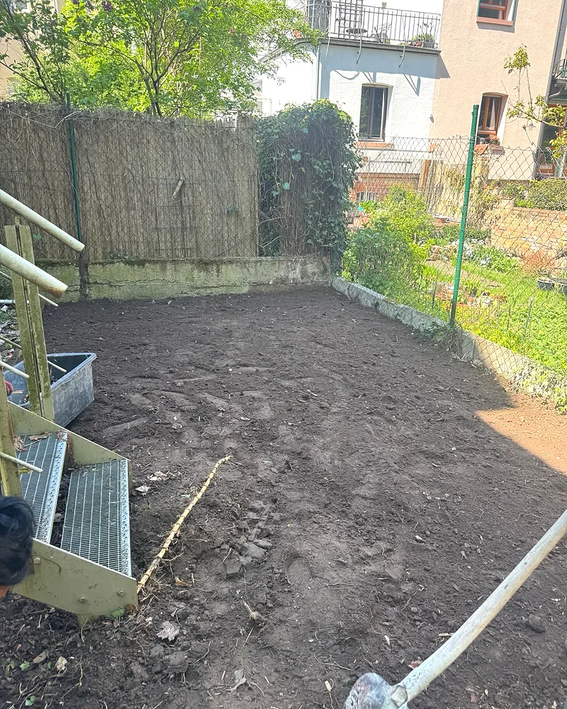 Garten in Worms vor der Neugestaltung: kahle, vorbereitete Erdfläche eines terrassierten Reihenhausgartens